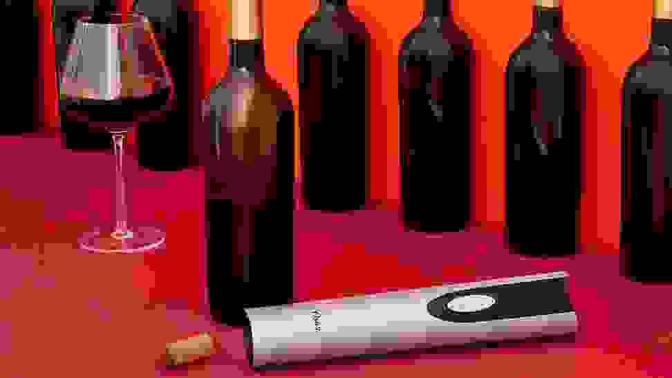 An electric wine bottle opener being used to open wine bottles.
