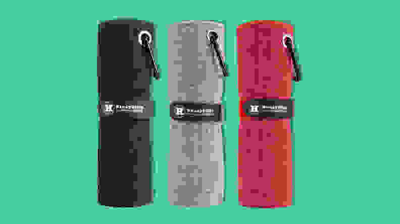 A blue, grey, and red HandyPicks microfiber golf towel on a green background.