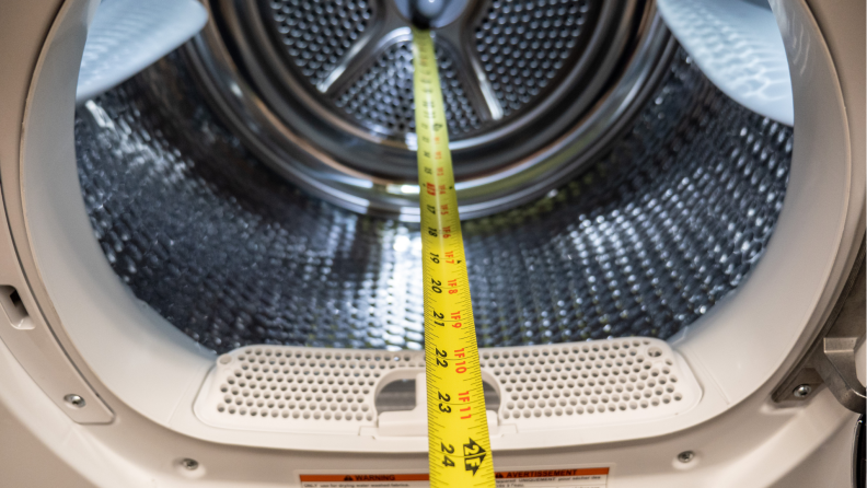 Measuring tape being used to measure the inside of a dryer from Bosch.